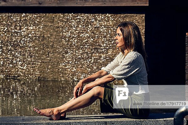 Mädchen entspannen unter der Sonne in der Nähe des Wassers in schwülen heißen Tag