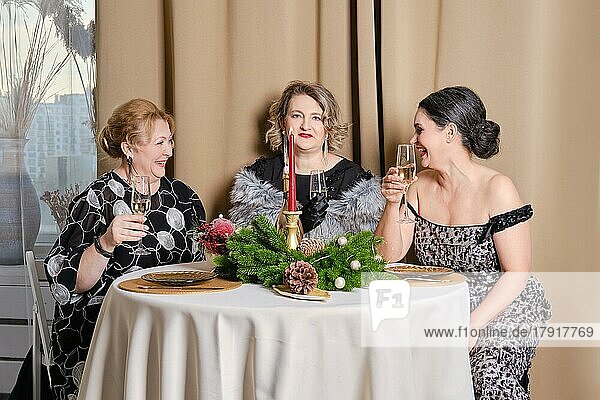 Drei fröhliche Frauen mittleren Alters  die Weihnachten feiern
