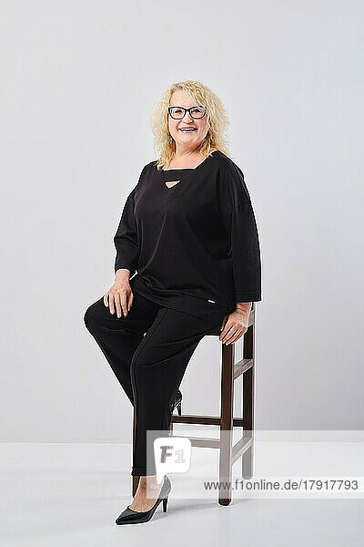 Happy middle age woman in black outfit  studio shot