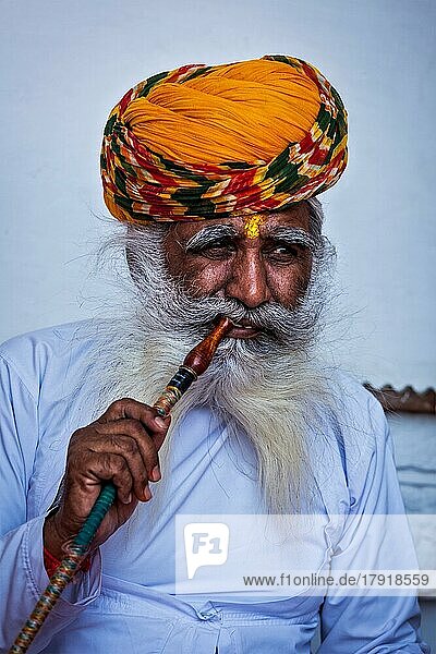 JODHPUR  INDIEN  26. NOVEMBER 2012: Ein alter indischer Mann raucht eine Wasserpfeife im Mehrangarh Fort. Es wird angenommen  daß das Konzept der Wasserpfeife seinen Ursprung in Indien hat