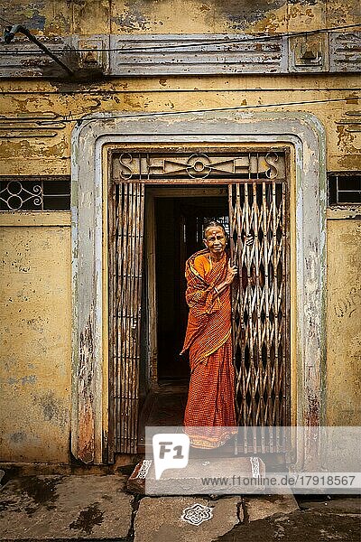 TIRUCHIRAPPALLI  INDIEN  15. FEBRUAR 2013: Nicht identifizierte indische Frau steht in der Tür ihres Hauses