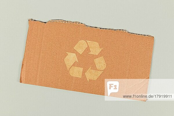Rotes Recycling-Pfeilsymbol auf einem Stück Karton