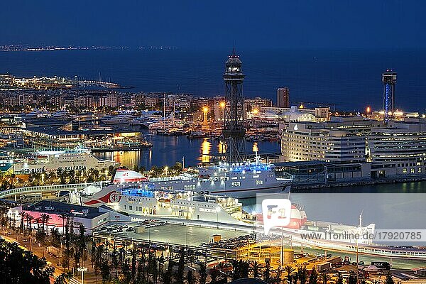 Luftaufnahme der Skyline von Barcelona mit Stadtverkehr und Hafen mit Yachten und Fährschiffen  die in der Nacht beleuchtet sind. Barcelona  Barcelona  Spanien  Europa