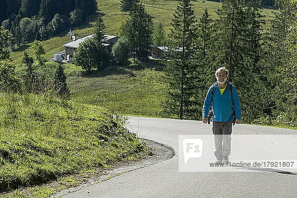 Wanderer unterwegs zum Spitzingsee  hinten Albert-Link-Hütte  Spitzingsee  Mangfallgebirge  Oberbayern  Deutschland  Europa