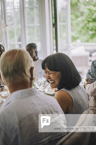 Glückliche Frau sieht Mann beim Abendessen auf einer Party an