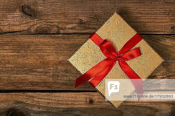 Geschenk Geschenk Geburtstag Weihnachten Konzept  Geschenk-Box mit roter Schleife auf hölzernen Hintergrund