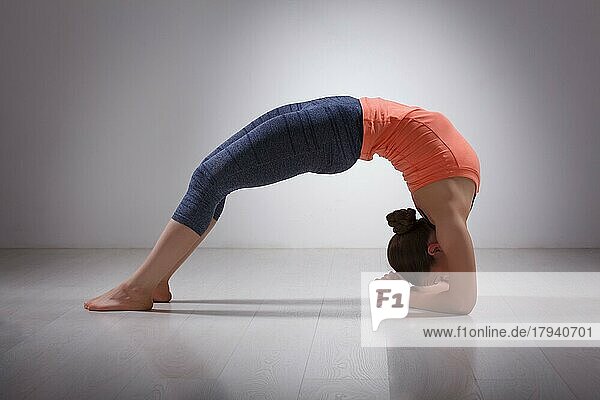 Schöne sportlich fit Yogini Frau Praktiken Yoga Asana viparita dandasana  nach oben gerichtet zwei Füße Stab Pose im Studio