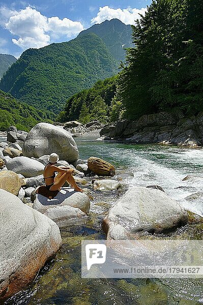 Junge Frau beim Sonnenbad an einem felsigen Voralpenbach im abgelegenen Val Verzasca  bei Lavertezzo  Tessin