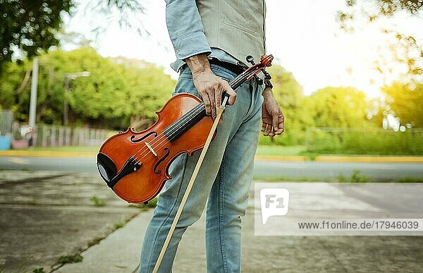Hände halten Geige und Reifen im Freien  Nahaufnahme von Händen halten Geige und Reifen. Konzept der Person hält Geige und Reifen im Freien