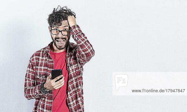 Besorgter Mann umklammert seinen Kopf hält Handy  Besorgte Person mit Handy hält seinen Kopf auf isolierten Hintergrund  schlechte Nachrichten Konzept auf Handy