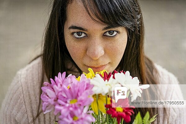 Nahaufnahme einer jungen lateinamerikanischen Frau  die einen Blumenstrauß hält