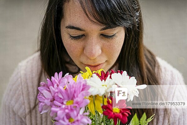 Nahaufnahme einer jungen lateinamerikanischen Frau  die einen Blumenstrauß hält