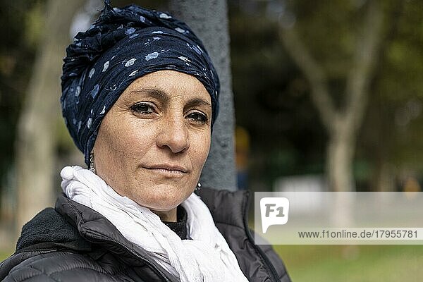 Porträt einer lateinamerikanischen Frau  die sich einer Krebsbehandlung unterzieht und ihren Kopf mit einem Schal bedeckt  der einen Ausdruck von Stärke vermittelt