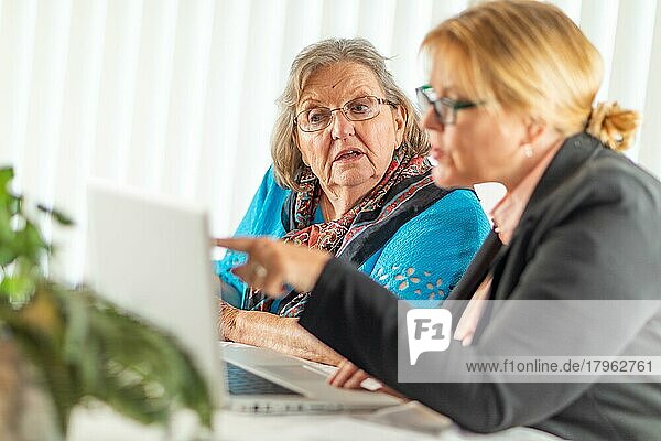 Frau hilft älterer erwachsener Dame am Laptop-Computer