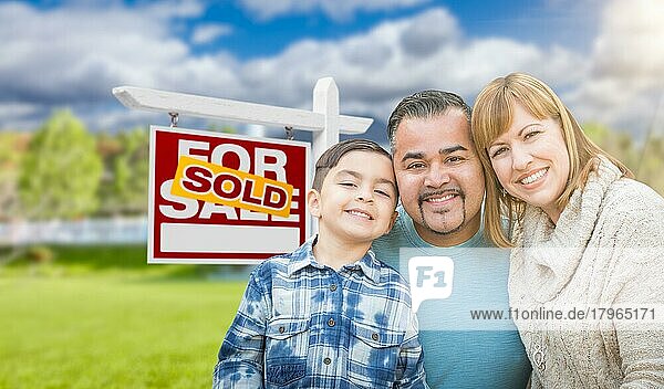 Gemischtrassige Familie vor einem Haus und einem Schild mit zu verkaufenden Immobilien