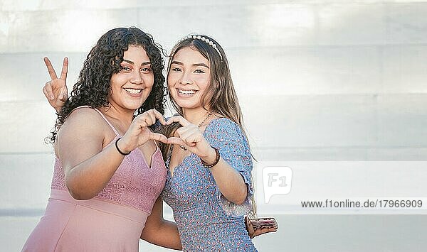 Close up of two girls forming heart with hands  two girls friends forming heart together