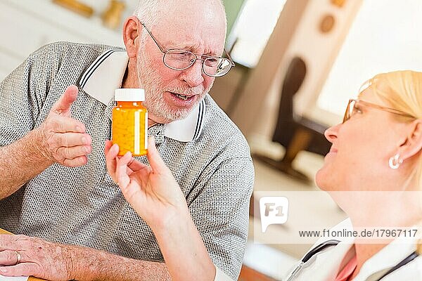 Ein Arzt oder eine Krankenschwester erklärt einem aufmerksamen älteren Mann ein verschreibungspflichtiges Medikament