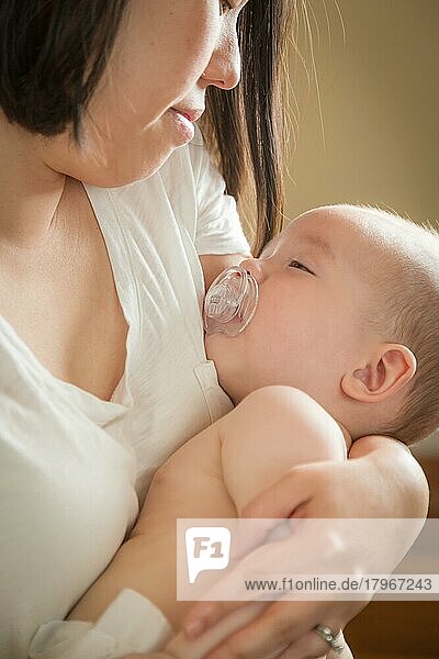 Gemischtrassiges chinesisches und kaukasisches Baby  das von seiner Mutter gehalten wird