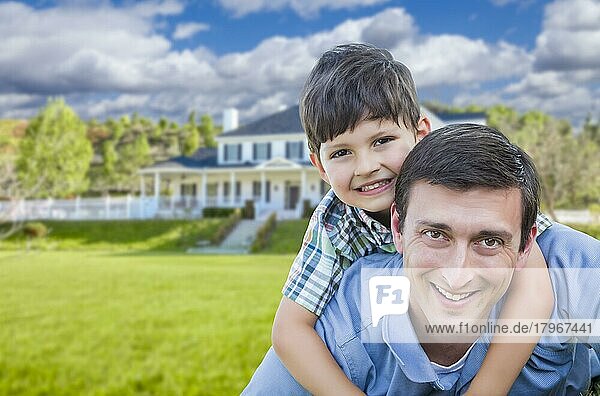 Gemischtrassiger Vater und Sohn spielen Huckepack vor ihrem Haus