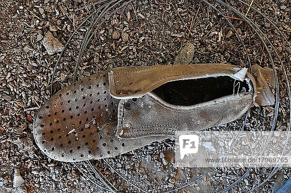 Maroder Herrenschuh aus Wildleder am Boden  verrotteter Schuh  Schuhwrack  vergammelter Treter  ausgelatschter Schuh  abgetragener Schuh