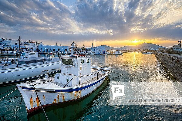 Altes Fischerboot im Hafen von Naousa bei Sonnenuntergang mit dramatischem Himmel. Insel Paros  Griechenland  Europa