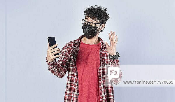 Mann macht Videoanruf isoliert  Mann macht Videoanruf mit Gesichtsmaske  Gesichtsmaske Videoanruf Konzept