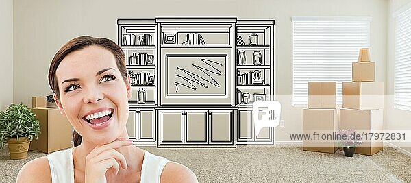 Frau in einem Raum mit Umzugskartons  die in Richtung eines Unterhaltungsgeräts an der Wand blickt