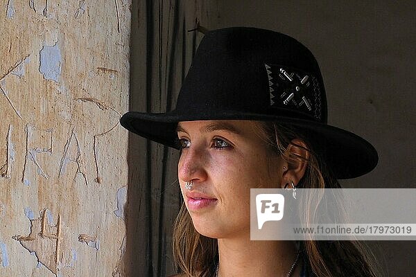 Young woman with black hat and nose piercing