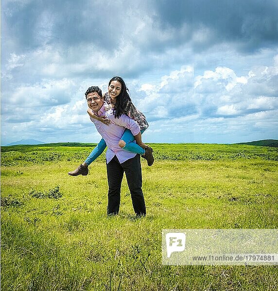 Glückliches verliebtes Paar auf dem Feld  glücklicher Mann trägt seine Freundin auf dem Feld