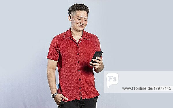 Hübscher Mann glücklich mit seinem Handy  junger lateinamerikanischer Mann glücklich mit seinem Handy