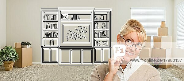 Frau in einem Raum mit Umzugskartons  die in Richtung eines Unterhaltungsgeräts an der Wand blickt