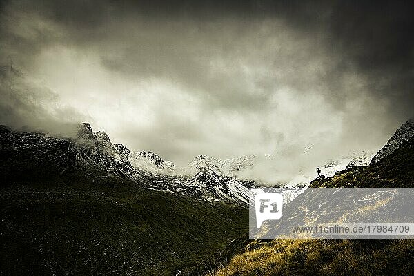 Bergsteiger vor dramatischen Wolken in Berglandschaft  Sellrain  Innsbruck  Tirol  Österreich  Europa