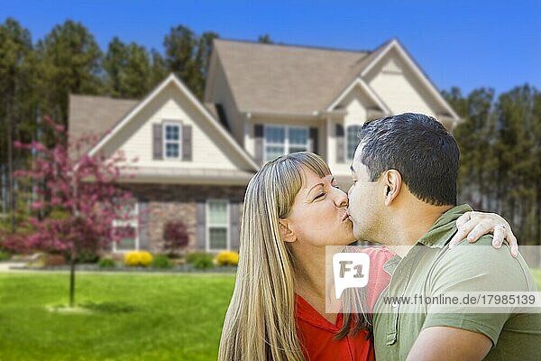 Glückliches  liebevolles  gemischtrassiges Paar  das sich vor einem Haus umarmt