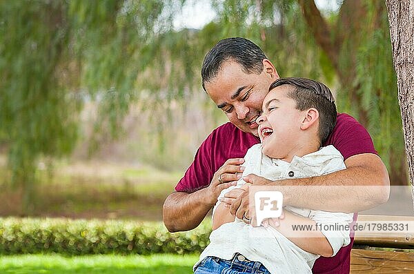 Gemischtrassiger hispanischer und kaukasischer Sohn und Vater haben Spaß im Park