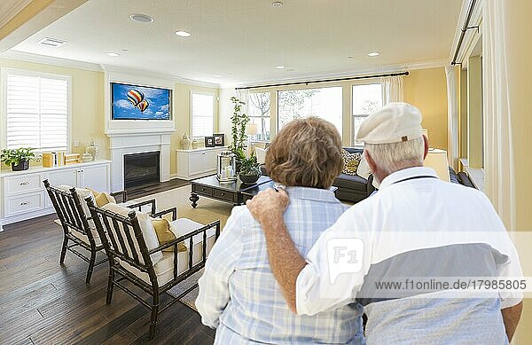 Liebevolles älteres Paar mit Blick auf ein schönes individuelles Wohnzimmer