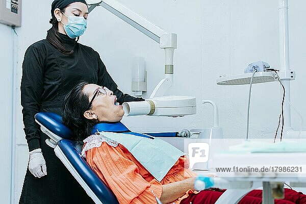 Eine Zahnärztin  die Röntgenaufnahmen macht  die Röntgenaufnahmen bei einem Patienten macht