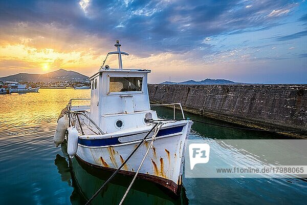 Altes Fischerboot im Hafen von Naousa bei Sonnenuntergang mit dramatischem Himmel. Insel Paros  Griechenland  Europa