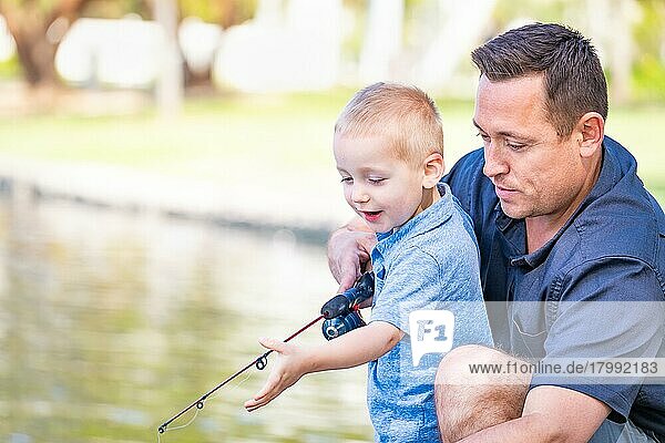Junger kaukasischer Vater und Sohn haben Spaß beim Angeln am See