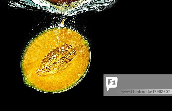 Die Hälfte der Orange Cantaloupe Melone sinken und vor schwarzem Hintergrund