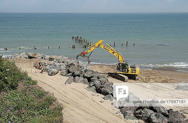 Bagger am Strand  repariert Seeverteidigung mit Felsblöcken  Happisburgh  Norfolk  England  August