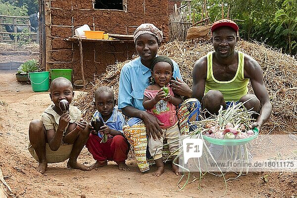 Familie zeigt im Garten angebautes Gemüse  Ruanda  Afrika