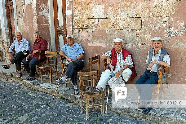 Turkish men sitting in front of house  Ayvalik  Cunda  Balikesir  Turkey  Asia