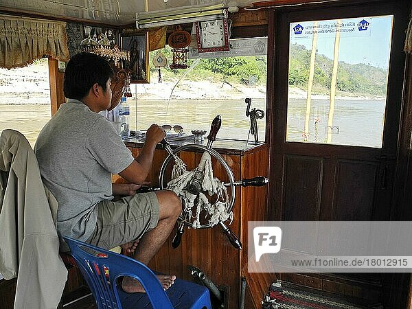 Kapitän am Ruderstand  Boot auf Fluss Mekong  Huay Xai  Pak Beng  Mekong  Laos  Asien