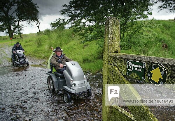 Schilder für Tramper Trail und öffentlichen Fußweg am Tor  Menschen mit Mobilitätsproblemen besuchen mit Trampern (Geländemobilen) den Bauernhof  Whitewell  Forest of Bowland  Lancashire  England  Juli