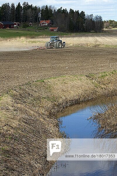 New Holland 8770 Traktor mit Eggen  Eggen-Feldsaatbett neben kleinem Fluss  Schweden  Mai  Europa