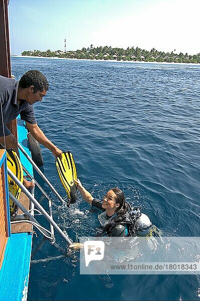 Diver boards boat  diving fins  fins  boat leader  helping hand  Maldives  Asia