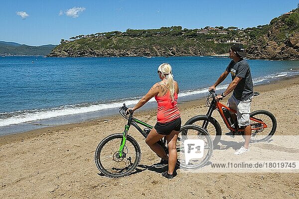 Paar mit Elektrofahrrad Fahrrädern am Strand  Europa  Morcone  Elba  Toskana  Italien  Europa