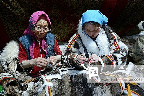Zwei Generationen von Nenet-Frauen  eine ältere Frau und ein Teegirl  nähen und tragen den traditionellen Mantel aus Rentierfell  Distrikt Yar-Sale  Jamal  Nordwest-Sibirien  Russland  Europa