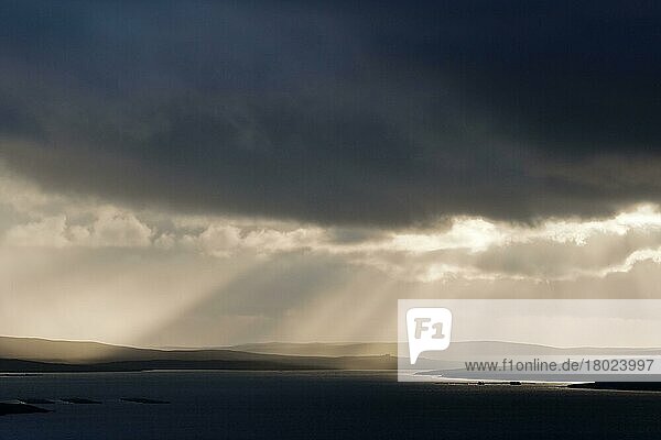 Stürmischer Abendhimmel mit Sonnenstrahlen über der Küste  Blick in Richtung Yell  Fetlar  Shetland-Inseln  Schottland  Juni