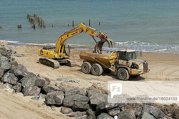 Bagger und Lastwagen am Strand  Reparatur der Seeverteidigung mit Felsblöcken  Happisburgh  Norfolk  England  August